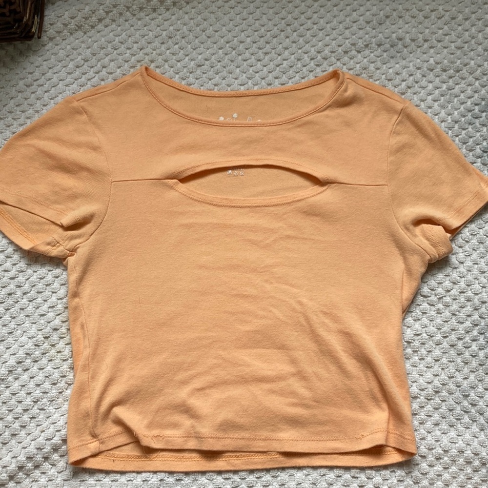 Pastel orange, crop top, with hole out for cleavage.
